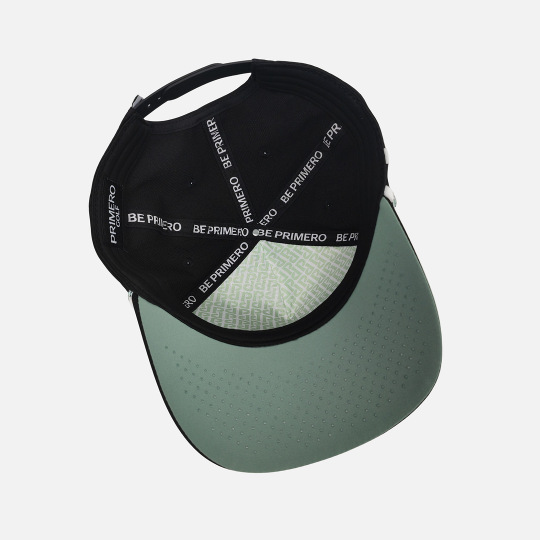 Black and green cap with 'BE PRIMERO' branding on a light gray background