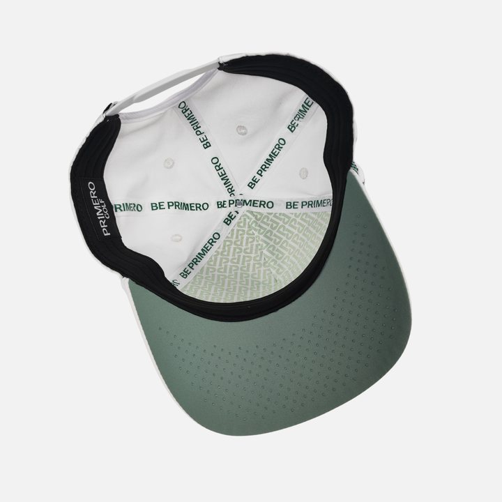 Golf hat with black and white brim and green bill on a light gray background