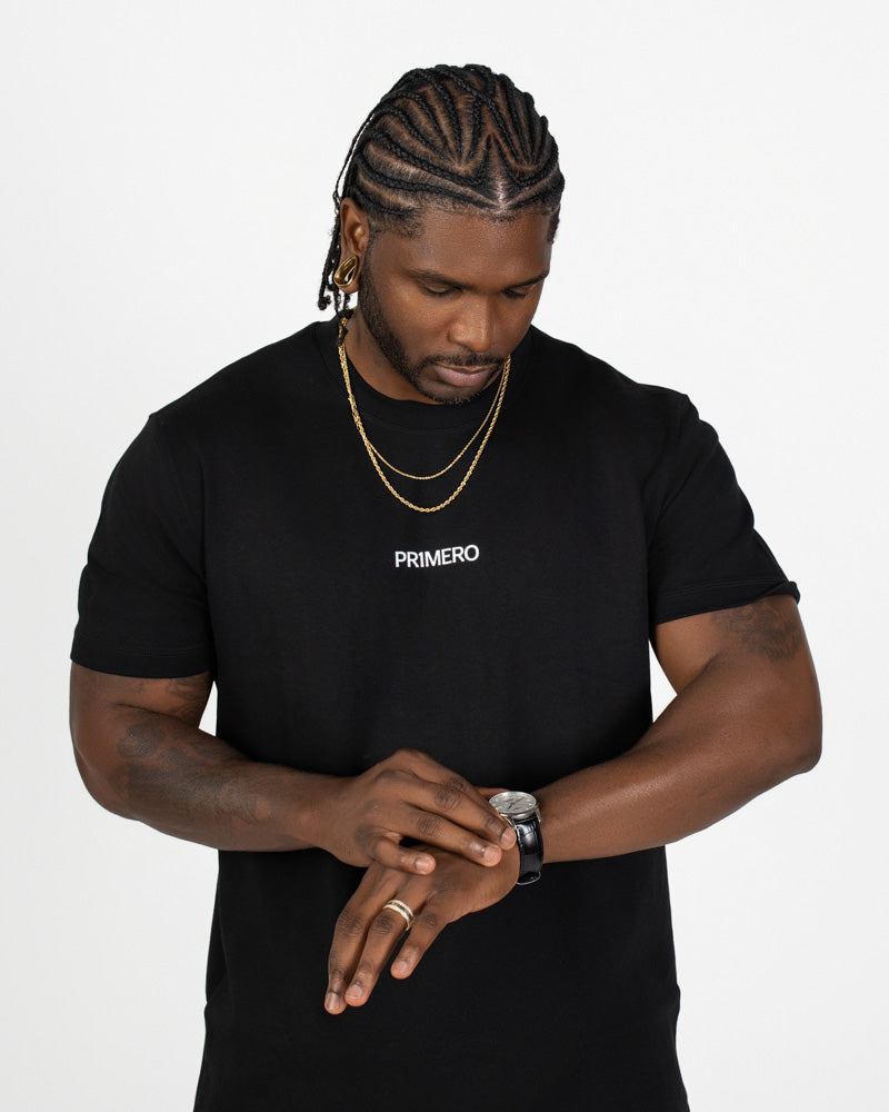 Man wearing a black t-shirt with 'PRIMERO' logo on a white background